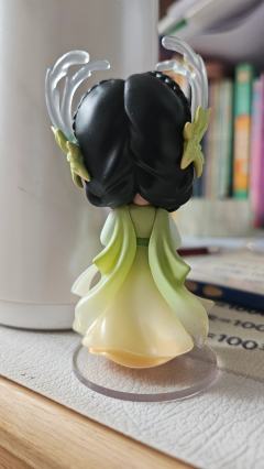 她自古典画卷中走来，墨发双辫绾着绿意花饰，渐变衣裙似裹挟着清