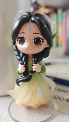 她自古典画卷中走来，墨发双辫绾着绿意花饰，渐变衣裙似裹挟着清