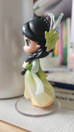 她自古典画卷中走来，墨发双辫绾着绿意花饰，渐变衣裙似裹挟着清