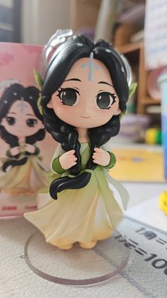 她自古典画卷中走来，墨发双辫绾着绿意花饰，渐变衣裙似裹挟着清