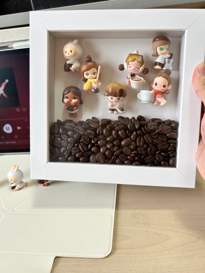 越来越多人问相框萌粒如何diy！
手把手教宝宝啦！
首选要选材料:
1.相框尺寸15cm×15cm
2.咖啡豆我选山姆的大概100g
3.泡泡玛特干燥剂很关键
4.圆点胶【双面胶】用来固定公仔的，也是